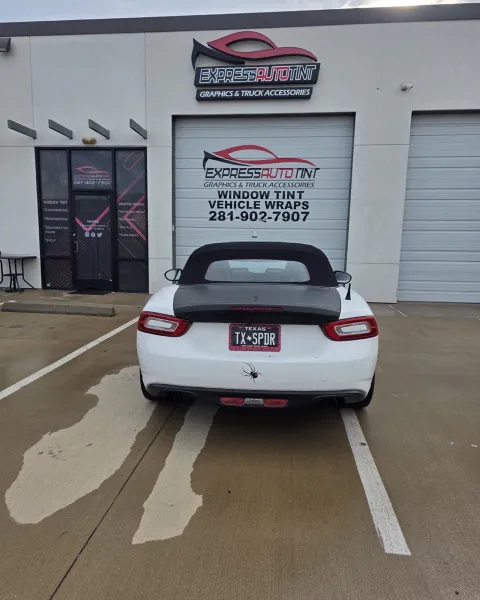 White convertible sports car in the ExpressAutoTNT bay in Katy