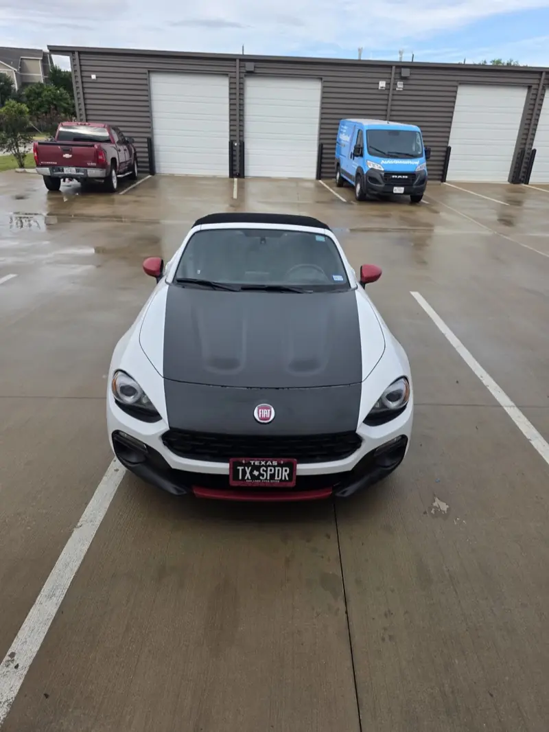 White convertible sports car with a matte black hood wrap, at ExpressAutoTNT in Katy, TX