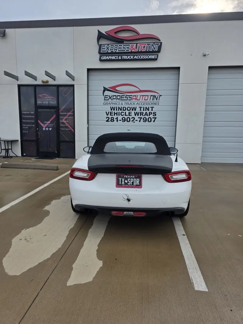White convertible sports car parked in front of the ExpressAutoTNT shop in Katy, TX