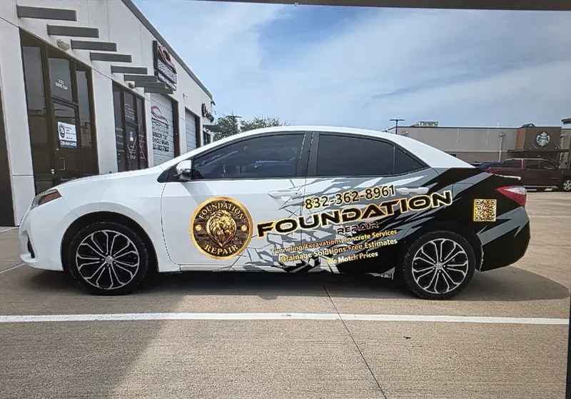 White sedan with a black and gold door graphic, by ExpressAutoTNT in Katy, TX