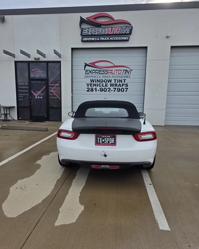 Glossy white convertible sports car in the ExpressAutoTNT service bay