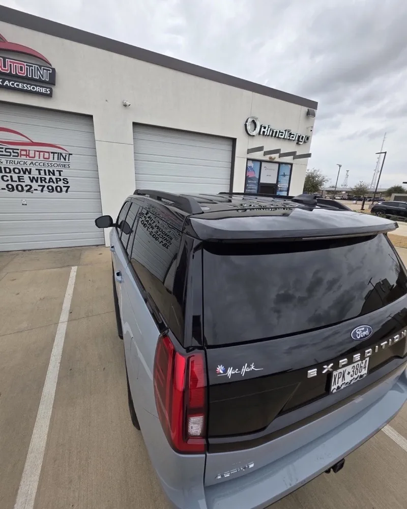 Full-size SUV with dark rear tint parked at the ExpressAutoTNT bay
