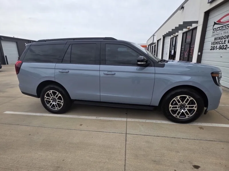 Full-size SUV with freshly tinted windows outside the ExpressAutoTNT bay in Katy